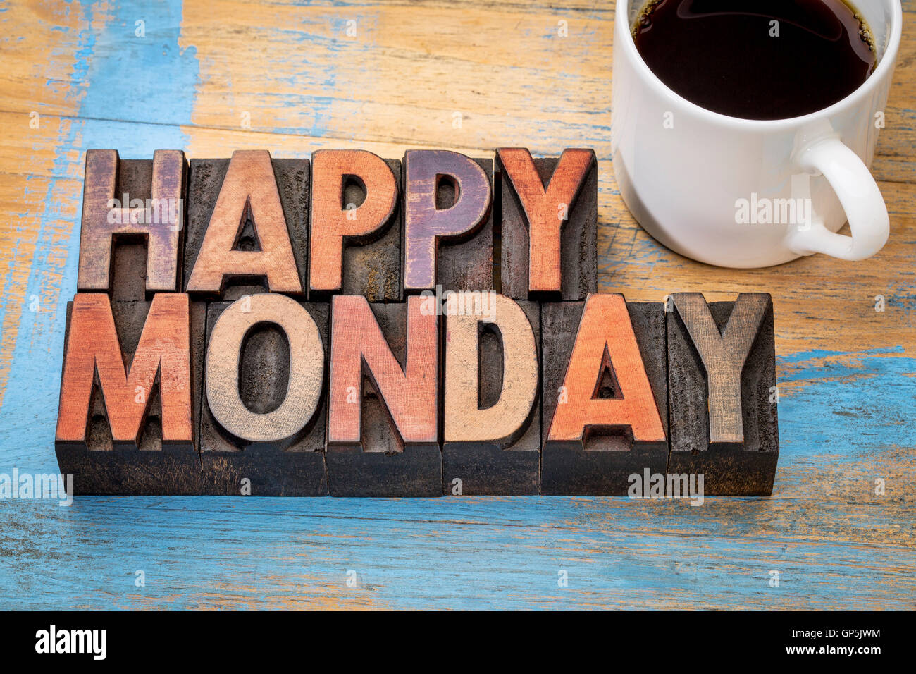Glücklich Montag Wort abstrakt in Vintage Buchdruck Holzart Druckstöcke befleckt durch Farbe Tinten mit einer Tasse Kaffee Stockfoto