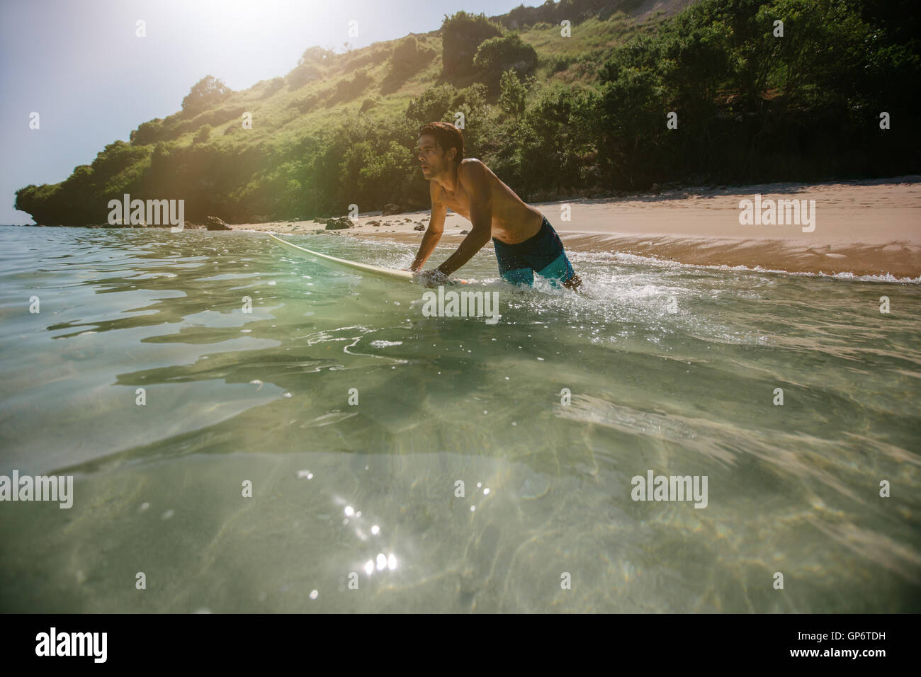Aufnahme des männlichen Surfer in das Meerwasser mit Surfbrett. Junger Mann im Meer Surfen. Stockfoto