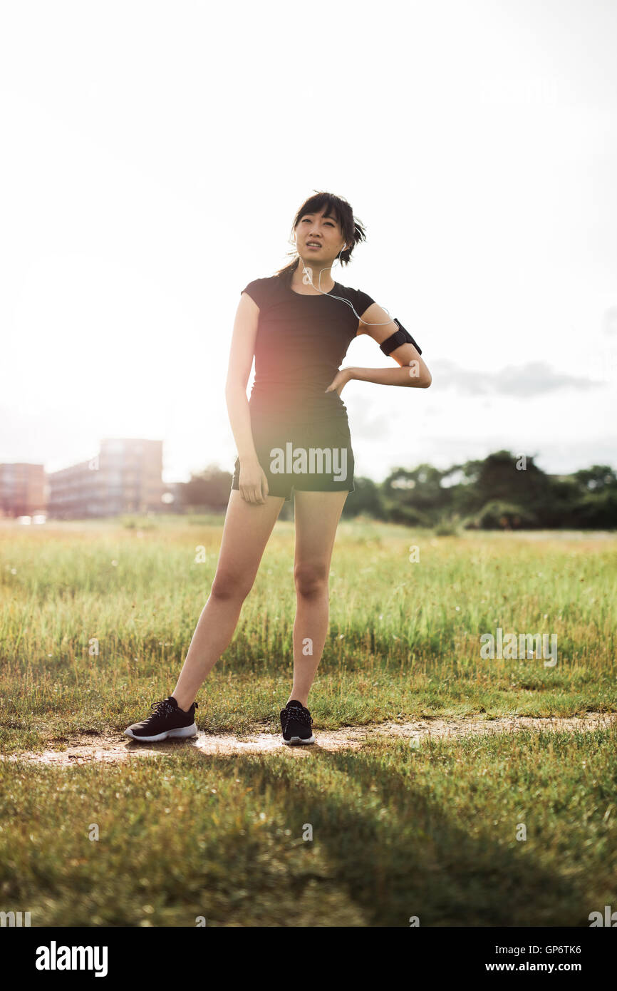 In voller Länge Portrait von einen fitten und gesunden jungen Frau Läufer steht im Stadtpark in Sportbekleidung bereit für ihre Morgengymnastik Stockfoto