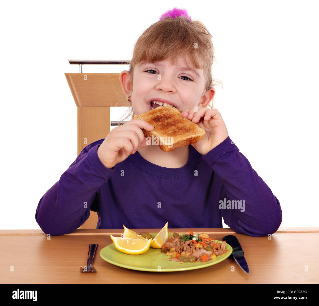 hungrige kleine Mädchen essen Brot Stockfoto