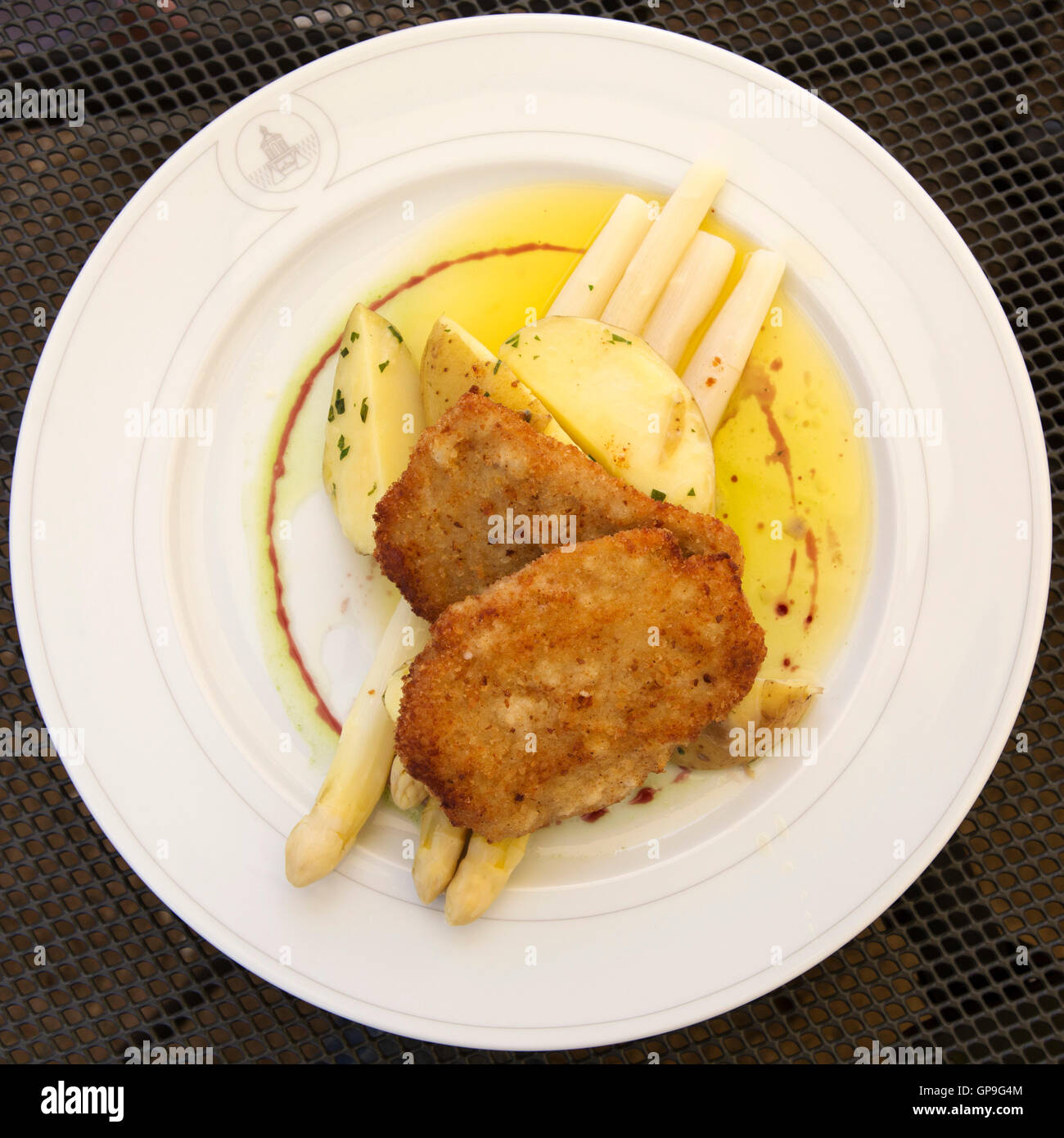 Ein Teller mit Schnitzel serviert mit Spargel in Dresden, Deutschland. Weißer Spargel ist eine saisonale, Frühling Köstlichkeit. Stockfoto