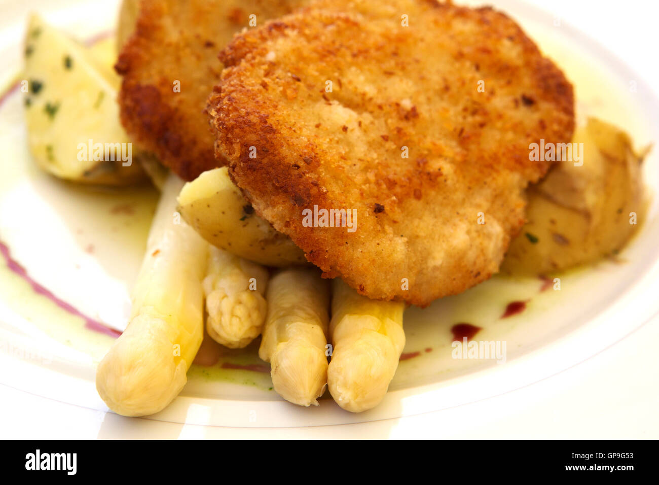 Ein Teller mit Schnitzel serviert mit Spargel in Dresden, Deutschland. Weißer Spargel ist eine saisonale, Frühling Köstlichkeit. Stockfoto