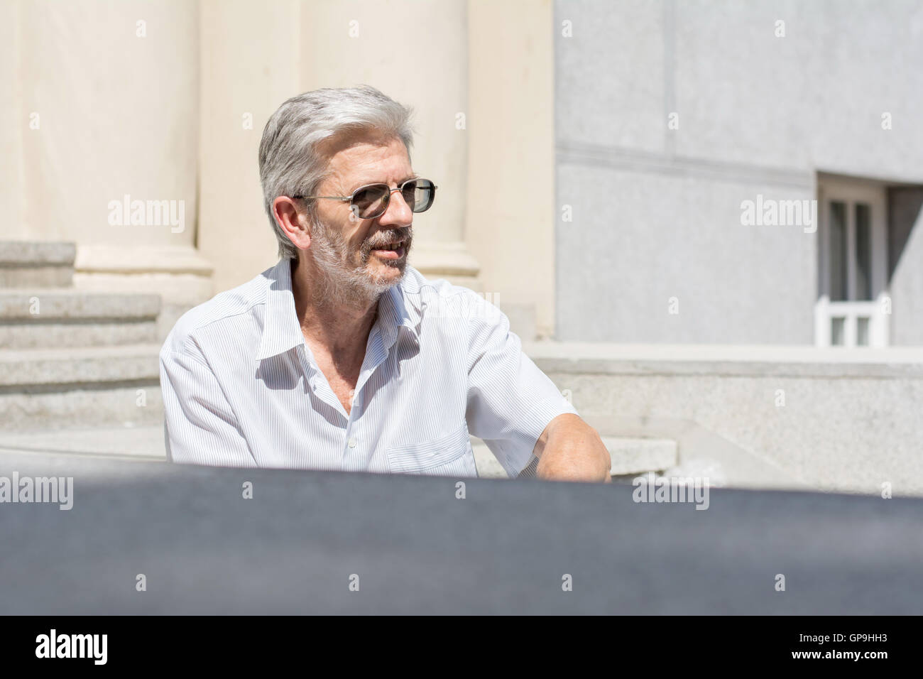 Modische senior Mann sitzt auf der Treppe Stockfoto