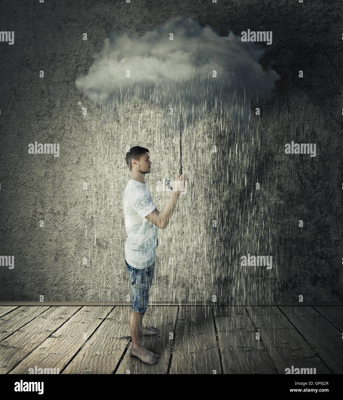 Junge Stand in einem Raum mit einer stürmischen, regnerischen Wolke als Dach. Pessimismus Geschäftskonzept Stockfoto