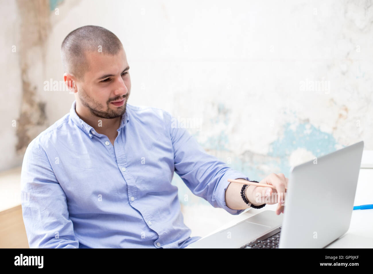 Junger Mann arbeiten am Laptop in He-Büro Stockfoto