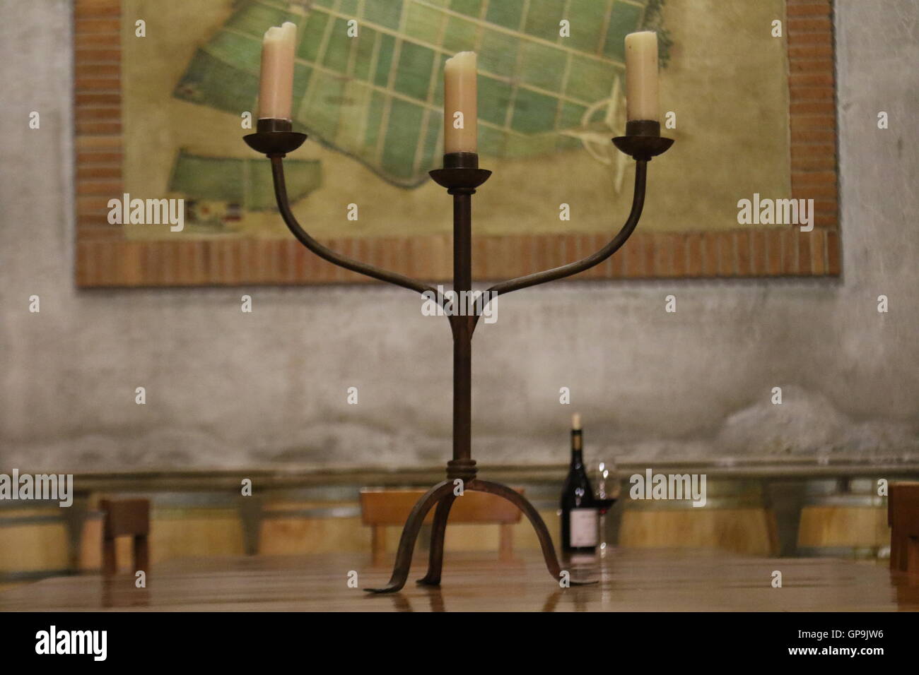 Kerzenständer auf einem Tisch mit Glas und Flasche Wein im Hintergrund De Martino Weinberge, Isla de Maipo, Chile Stockfoto