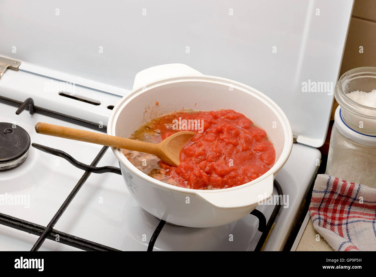 Küche die Bolognese-Sauce, genannt auch Ragu, in der Küche zu Hause. Zwiebel, Tomate und Fleisch in den Topf mit einem Holzlöffel. Stockfoto