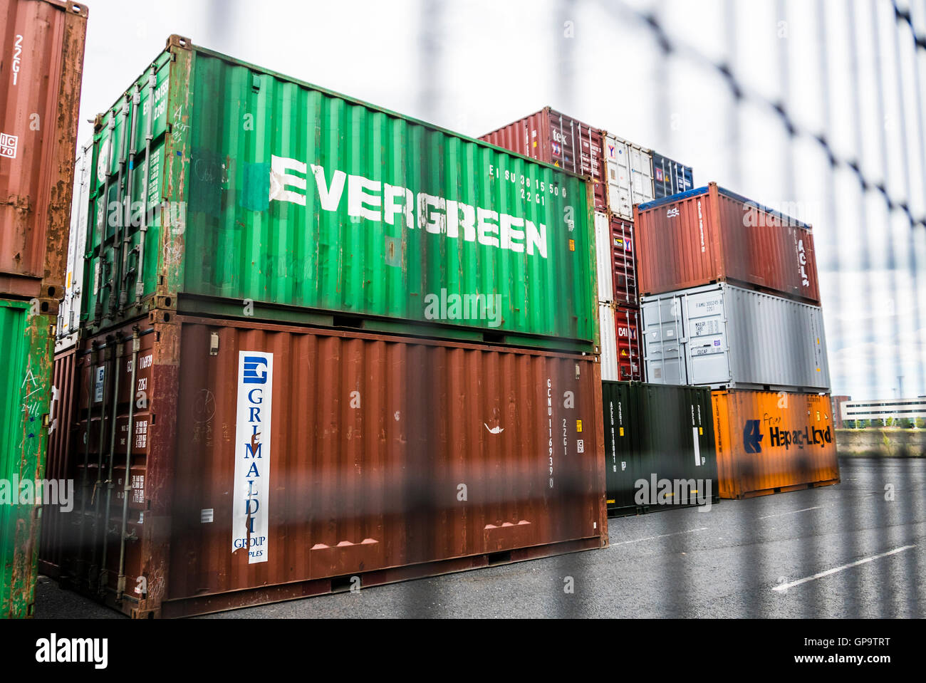 See-Container stapeln sich am Hafen von Belfast, hinter einem Sicherheitszaun. Stockfoto