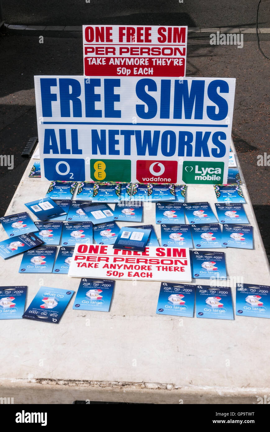 Kostenlose SIM-Karten für Mobiltelefone auf einem Marktstand mit Schild beraten Menschen, eine pro Person, inklusive grammatische Erro nehmen Stockfoto