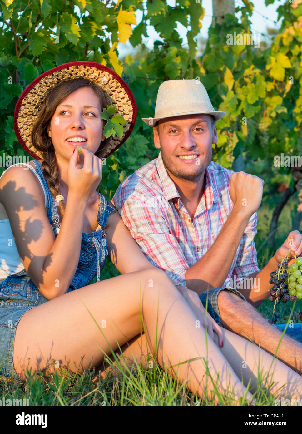 Glückliches Paar essen frische Trauben im Weinberg Stockfoto