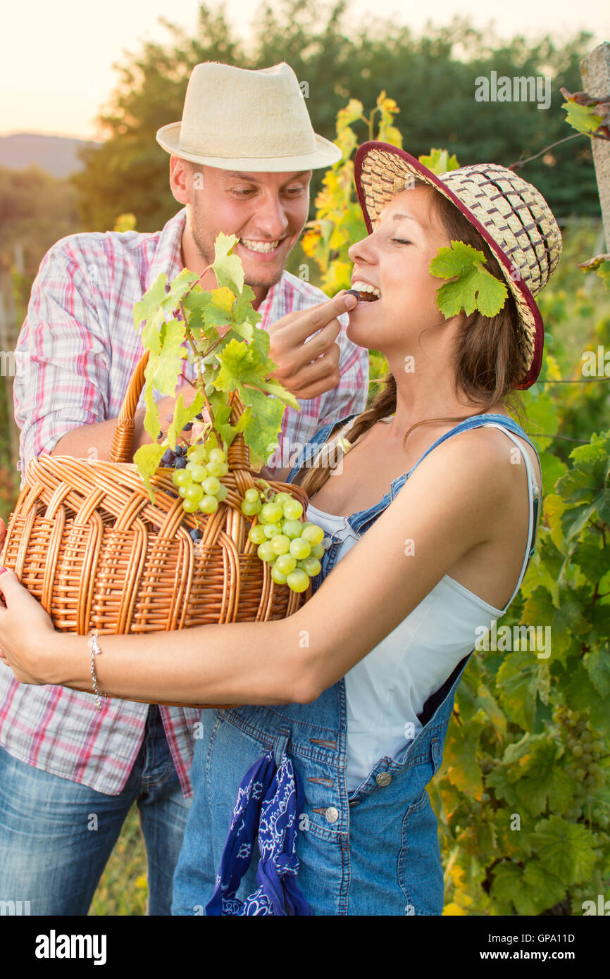 Glückliches Paar auf einem Weingut hält einen Weidenkorb Stockfoto