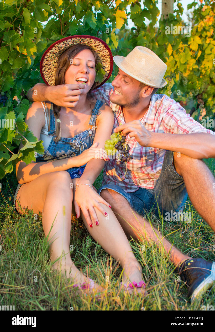 Glückliches Paar essen frische Trauben im Weinberg Stockfoto
