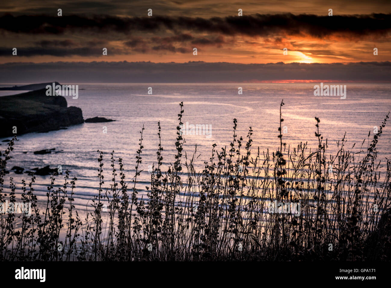 Ein spektakulärer Sonnenuntergang bricht über die Küste von North Cornwall. Stockfoto