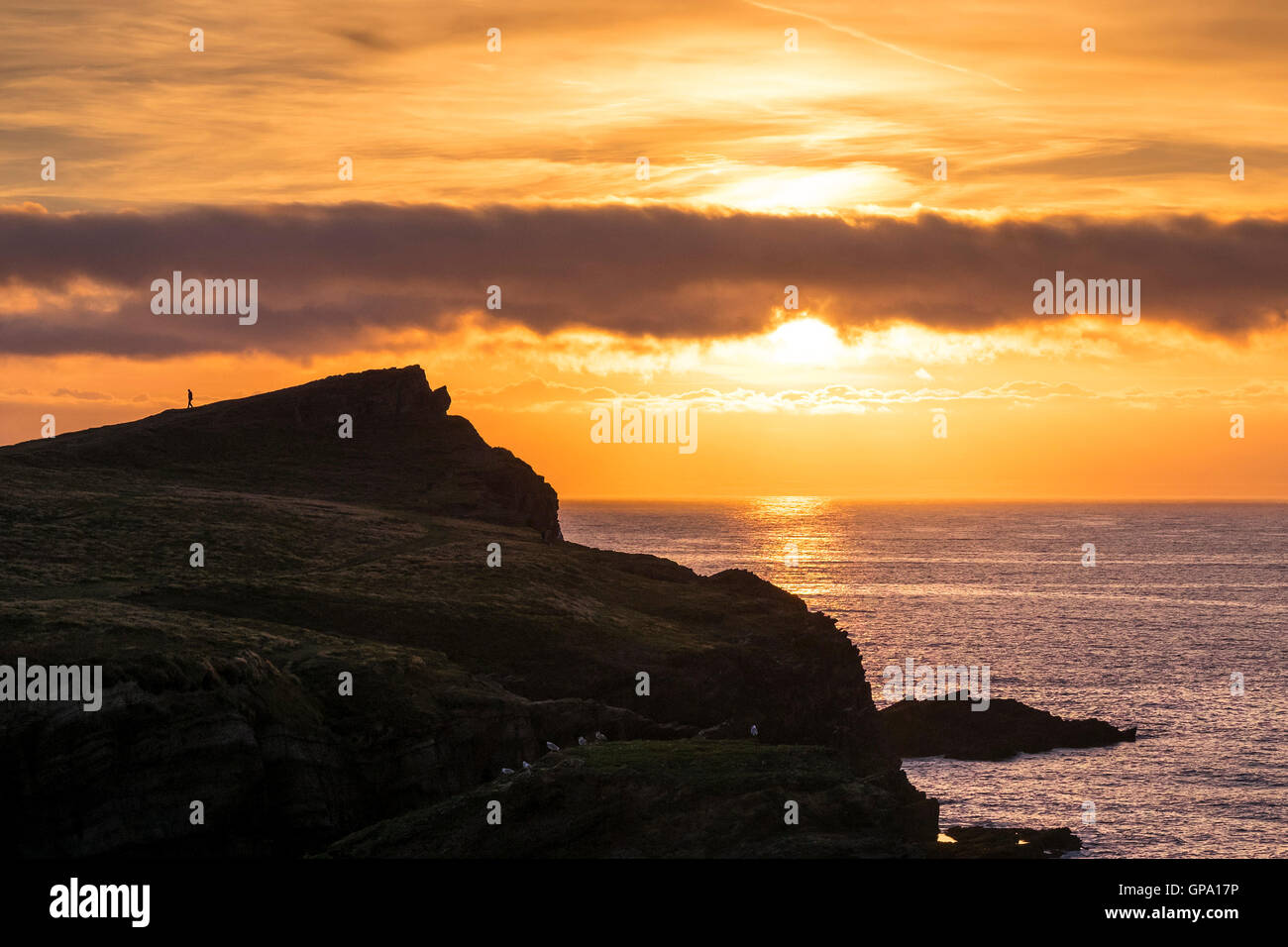 Ein spektakulärer Sonnenuntergang baut über Porth Insel und Trevelgue Head in Newquay, Cornwall. Stockfoto