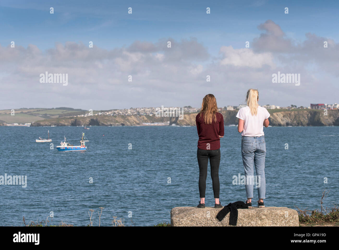 Zwei Urlauber stehen und genießen Sie den Blick über die Bucht von Newquay in Cornwall. Stockfoto