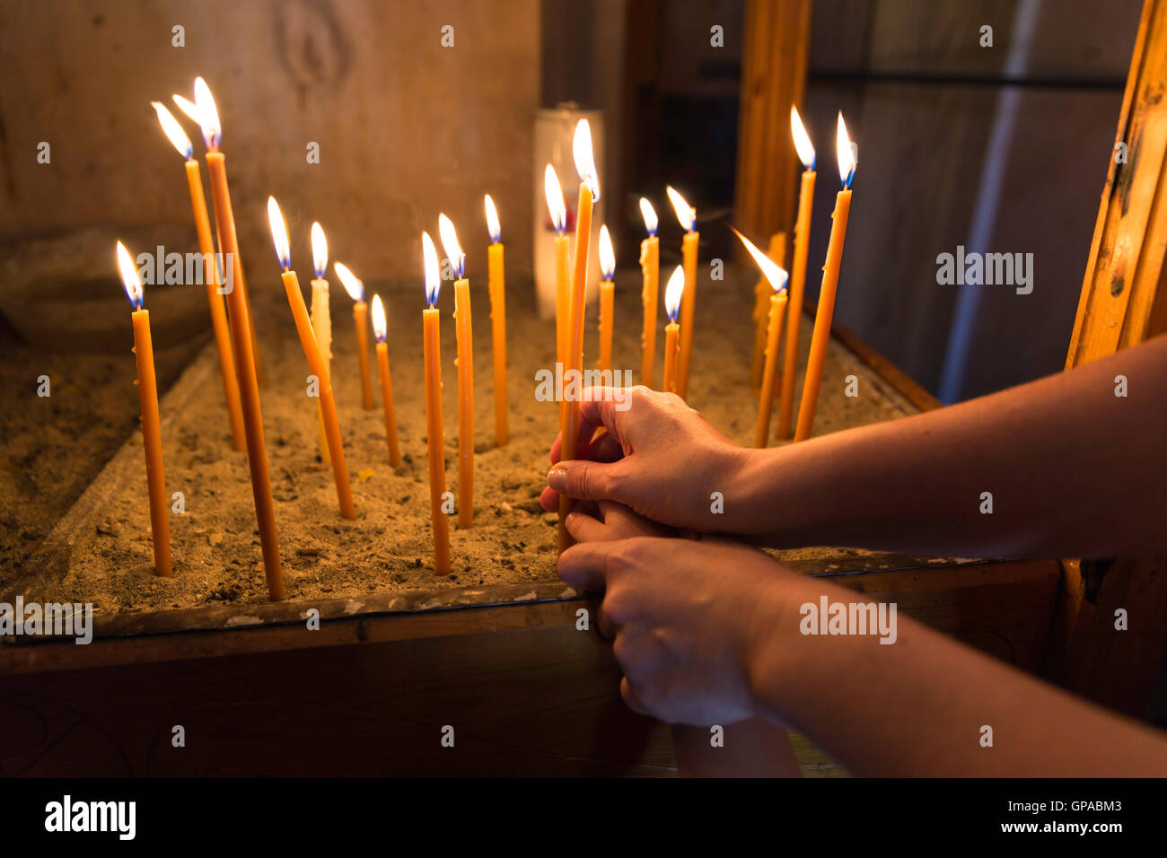Mutter und Kind, Beleuchtung und hält eine Kerze in der orthodoxen Kirche Stockfoto