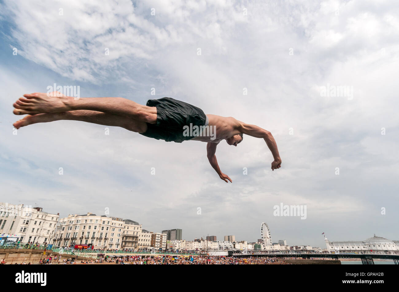 Jugendliche, Tauchen und springen ins Meer aus einer Buhne auf Brighton Seafront. Stockfoto
