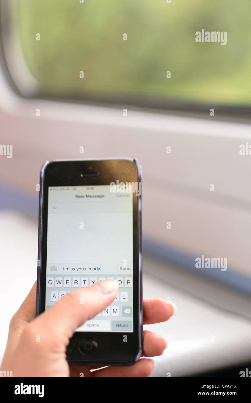 London, UK - 31. August 2016: zarte Frauenhand hält ein Iphone 5 mit Text Worte geschrieben "Ich vermisse Sie schon" Stockfoto