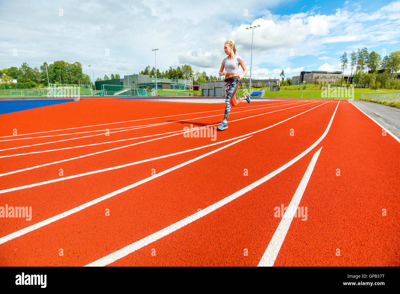 Junge Frau läuft auf Sport Tracks Stockfoto