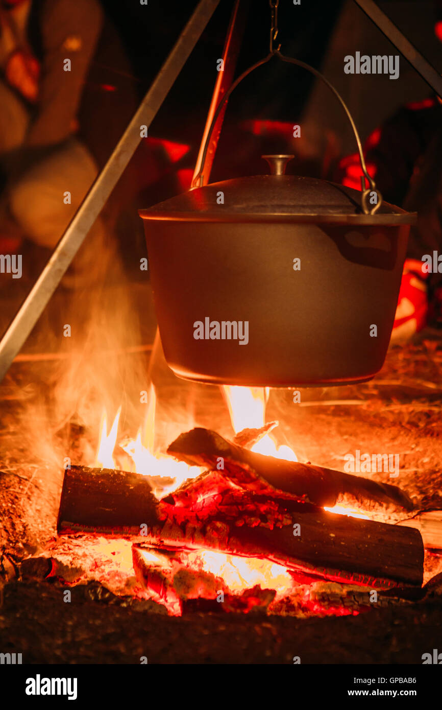 kochender Topf über dem offenen Feuer auf der Hintergrund jedoch unscharf. Stockfoto