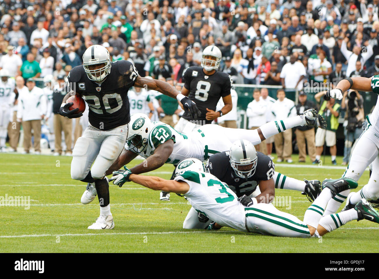 Sep 25, 2011; Oakland, Kalifornien, USA;  Oakland Raiders Runningback Darren McFadden (20) bricht ein Tackling von New York Jets innen Linebacker David Harris 52-zu-Noten einen Touchdown im ersten Quartal O.co Coliseum. Stockfoto