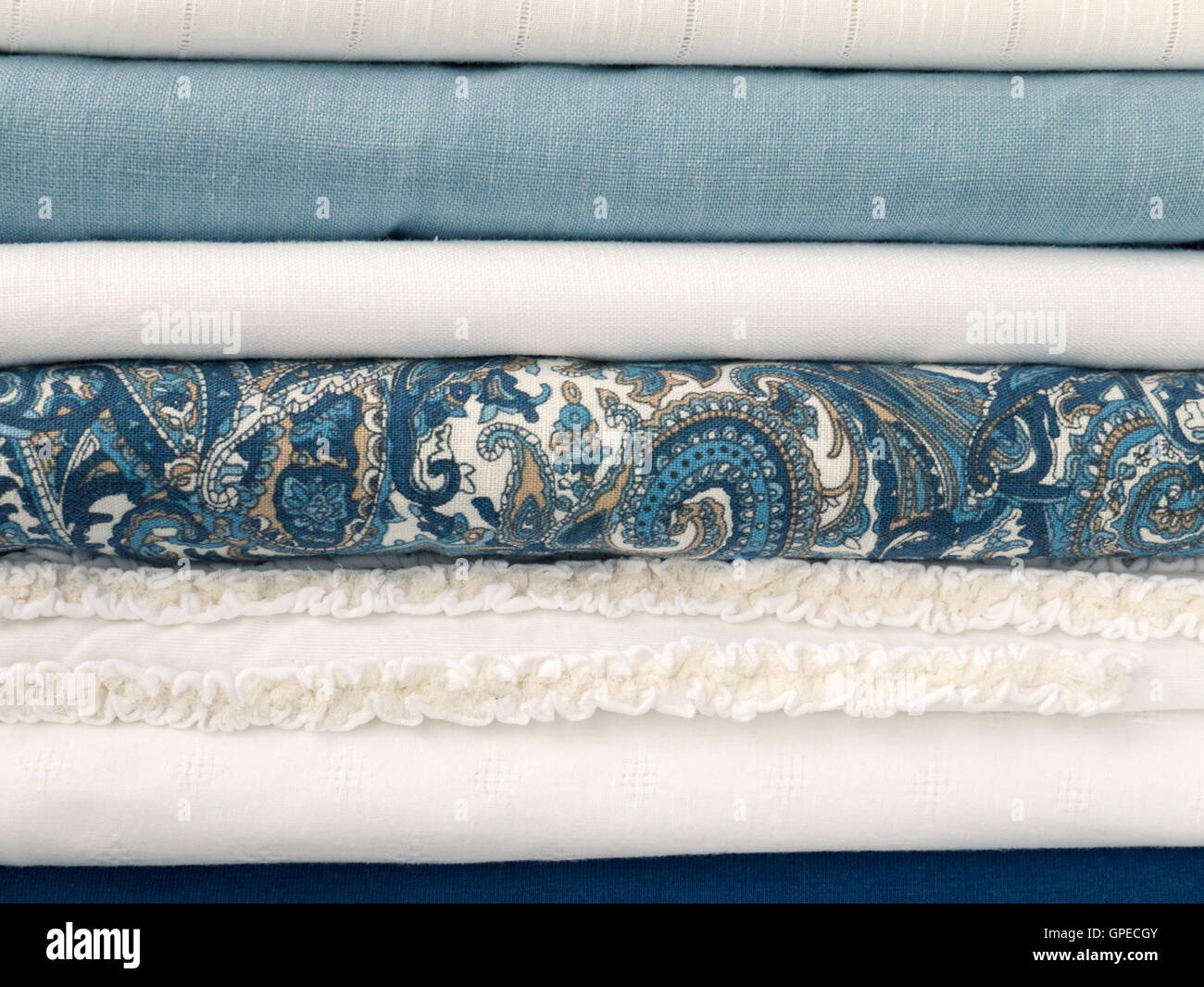 Stapel von kühlen weißen und blauen Sommerkleidung mit unterschiedlichen Texturen Stockfoto