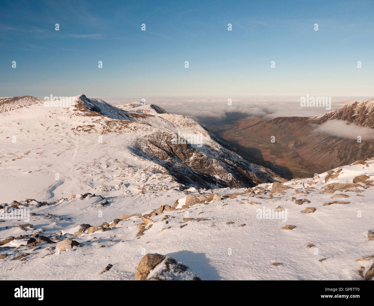 Eine schneebedeckte Y Garn im Winter, betrachtet von Glyder Fawr wie eine Wolke Inversion Nant Ffrancon fegt. Snowdonia-Nationalpark Stockfoto