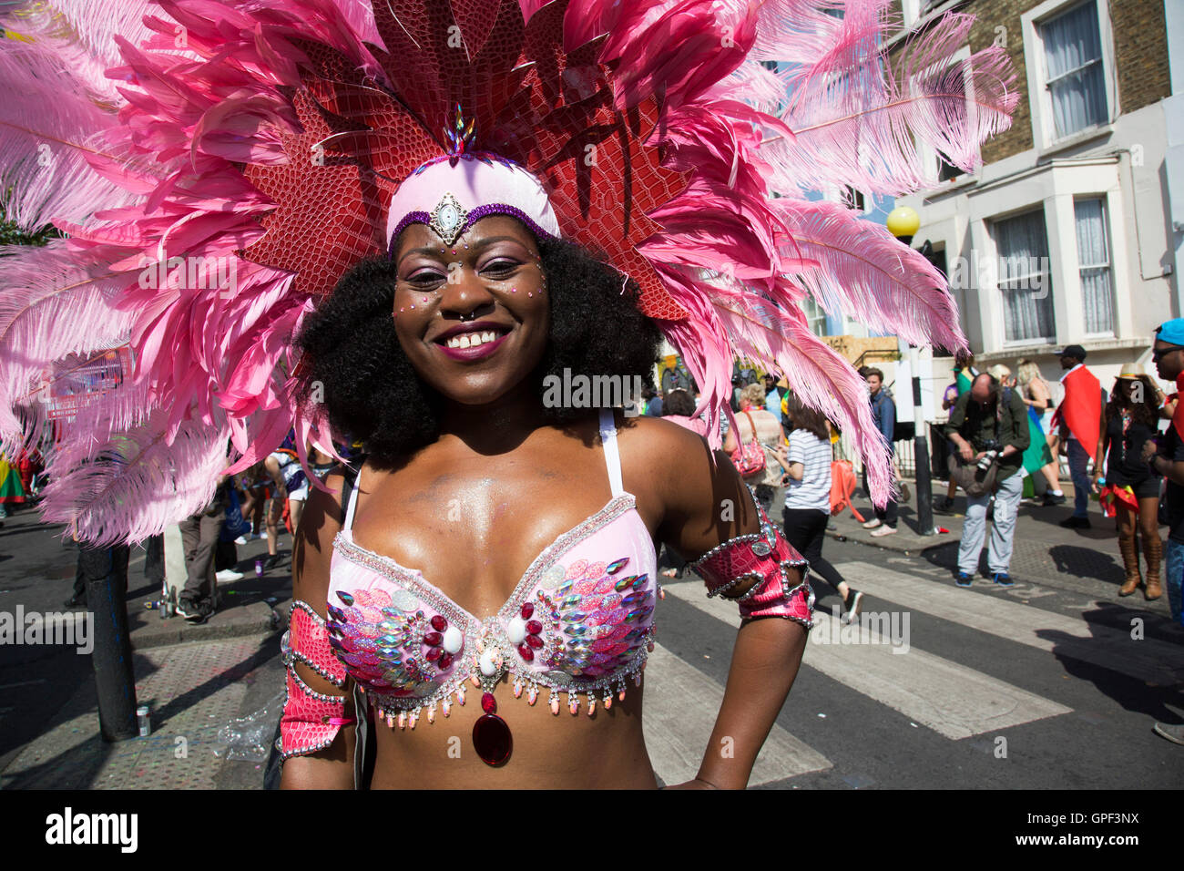 Parade-Tänzer in Feder Kostümen auf Sonntag, 28. August 2016 in Notting Hill Carnival in Westlondon. Ein Fest der Westindischen / Karibik Kultur und Europas größte Straßenparty, Festival und Parade. Nachtschwärmer kommen in hunderttausenden zum Spaß haben, tanzen, trinken und loslassen in die tolle Atmosphäre. Es wird geführt von den Mitgliedern der West-indischen / Karibische Gemeinschaft, besonders die Trinidad und Tobagonian britische Bevölkerung, von denen viele seit den 1950er Jahren in der Gegend gelebt haben. Der Karneval hat in der Vergangenheit und Zentren auf eine Parade der Wagen bis zu 2 Millionen Menschen angezogen, Stockfoto