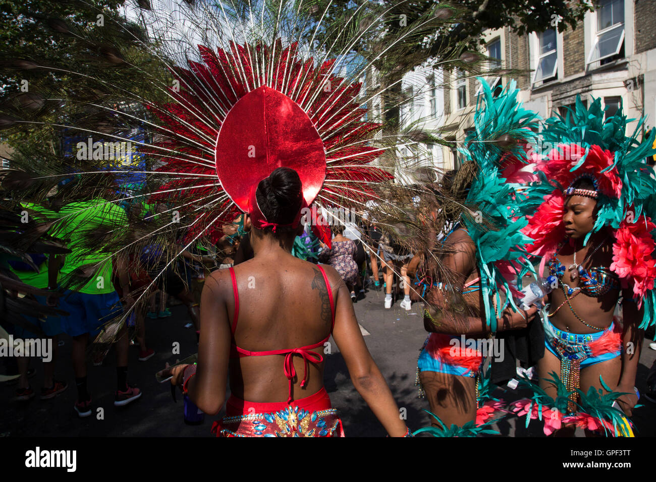 Parade-Tänzer in Feder Kostümen auf Sonntag, 28. August 2016 in Notting Hill Carnival in Westlondon. Ein Fest der Westindischen / Karibik Kultur und Europas größte Straßenparty, Festival und Parade. Nachtschwärmer kommen in hunderttausenden zum Spaß haben, tanzen, trinken und loslassen in die tolle Atmosphäre. Es wird geführt von den Mitgliedern der West-indischen / Karibische Gemeinschaft, besonders die Trinidad und Tobagonian britische Bevölkerung, von denen viele seit den 1950er Jahren in der Gegend gelebt haben. Der Karneval hat in der Vergangenheit und Zentren auf eine Parade der Wagen bis zu 2 Millionen Menschen angezogen, Stockfoto