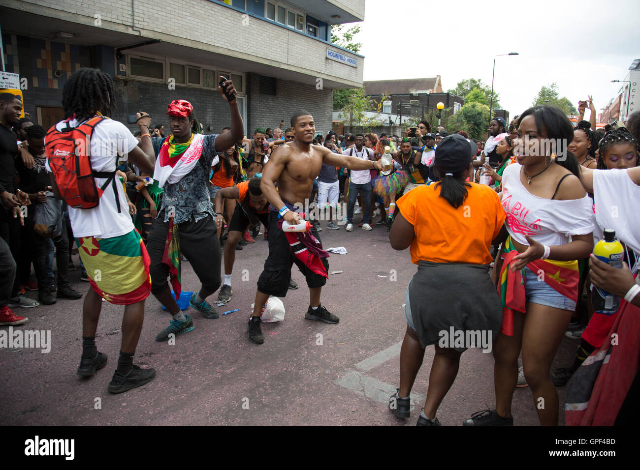 Bilden einen Kreis, die dann jeder stürzt in, in einer Explosion von fröhlichen Tanz auf Sonntag, 28. August 2016 bei den 50. Notting Hill Carnival in Westlondon. Ein Fest der Westindischen / Karibik Kultur und Europas größte Straßenparty, Festival und Parade. Nachtschwärmer kommen in hunderttausenden zum Spaß haben, tanzen, trinken und loslassen in die tolle Atmosphäre. Es wird geführt von den Mitgliedern der West-indischen / Karibische Gemeinschaft, besonders die Trinidad und Tobagonian britische Bevölkerung, von denen viele seit den 1950er Jahren in der Gegend gelebt haben. Der Karneval hat bis zu 2 Millionen angezogen. Stockfoto
