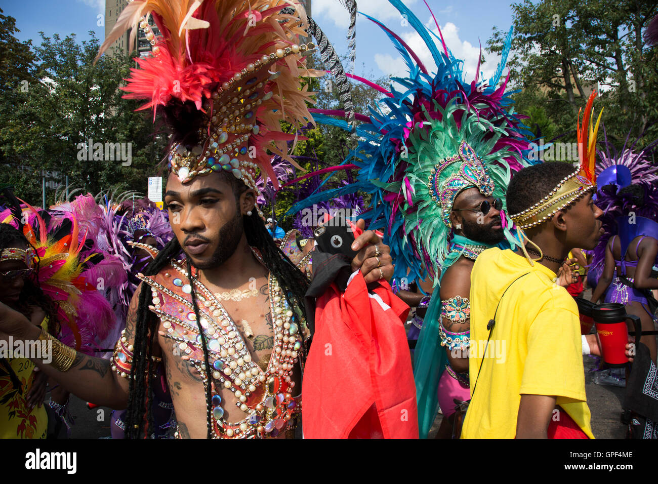 Parade-Tänzer in Feder Kostümen auf Sonntag, 28. August 2016 bei den 50. Notting Hill Carnival in Westlondon. Ein Fest der Westindischen / Karibik Kultur und Europas größte Straßenparty, Festival und Parade. Nachtschwärmer kommen in hunderttausenden zum Spaß haben, tanzen, trinken und loslassen in die tolle Atmosphäre. Es wird geführt von den Mitgliedern der West-indischen / Karibische Gemeinschaft, besonders die Trinidad und Tobagonian britische Bevölkerung, von denen viele seit den 1950er Jahren in der Gegend gelebt haben. Der Karneval hat in der Vergangenheit und Zentren auf eine Parade von bis zu 2 Millionen Menschen angezogen. Stockfoto