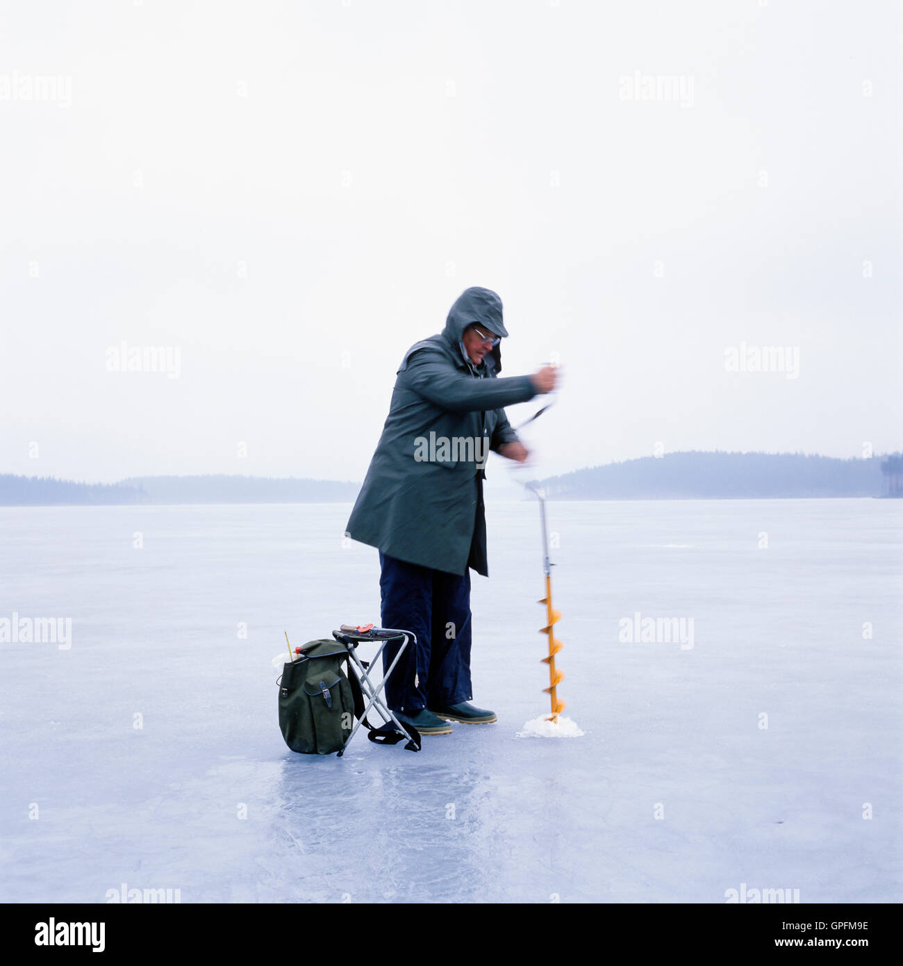 Angeln am zugefrorenen See, Schweden Stockfoto