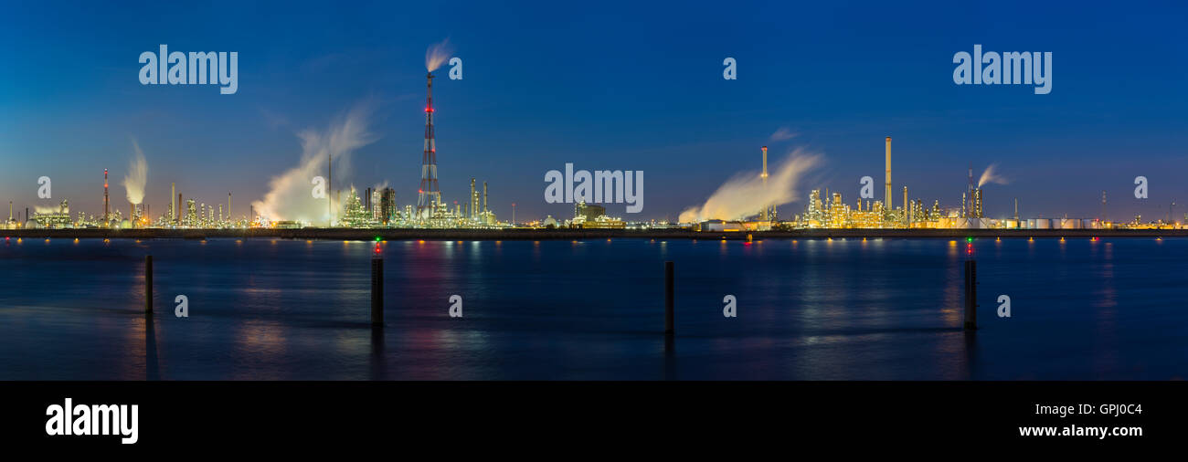 Herrliche Sicht über die Schelde in Antwerpen, Belgien, eine große Erdölraffinerie mit blauen Nachthimmel, Beleuchtung und Dampf. Stockfoto