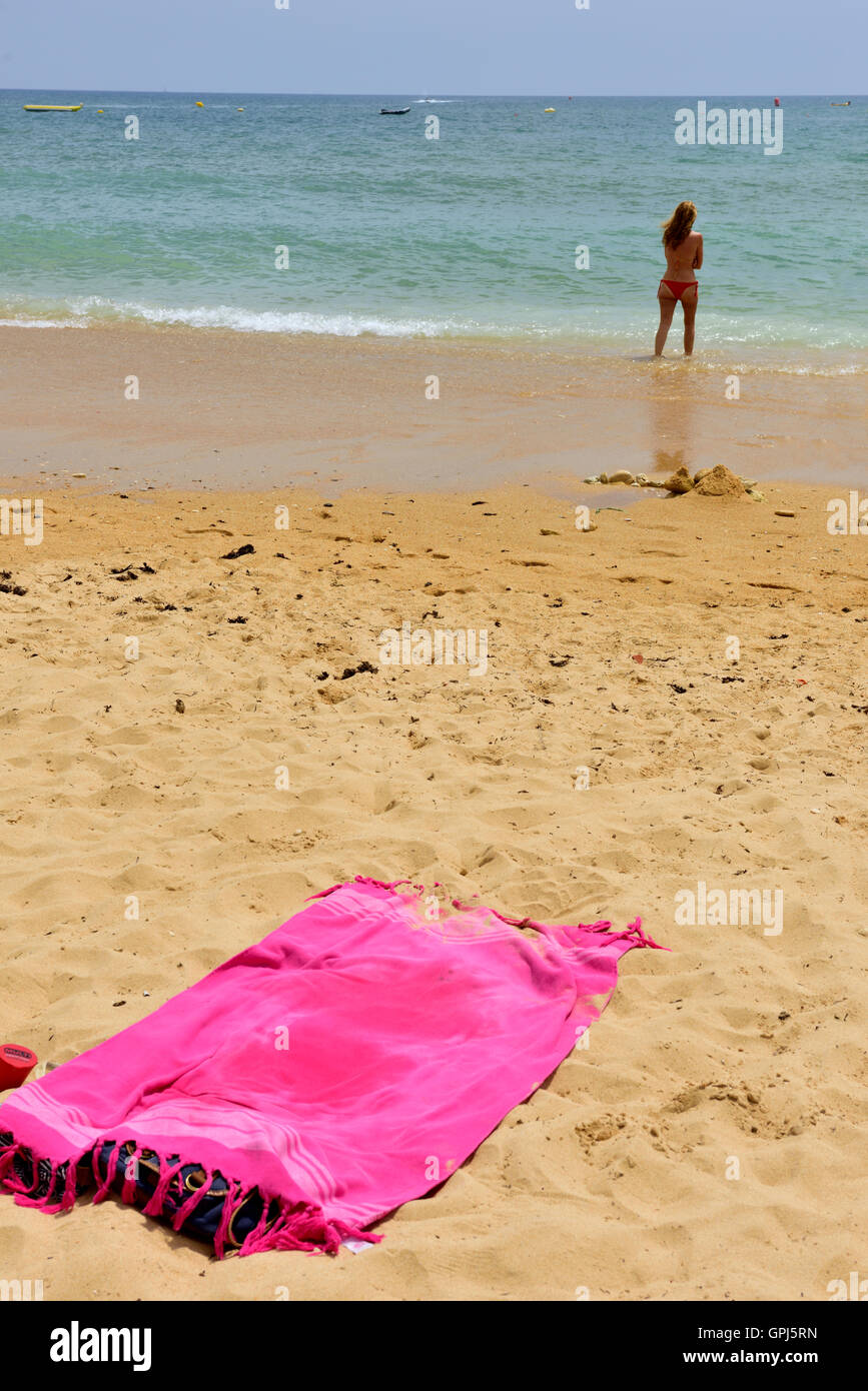 Rosa leeren Strandhandtuch auf Sand mit einsamen Frau vom Meer Stockfoto