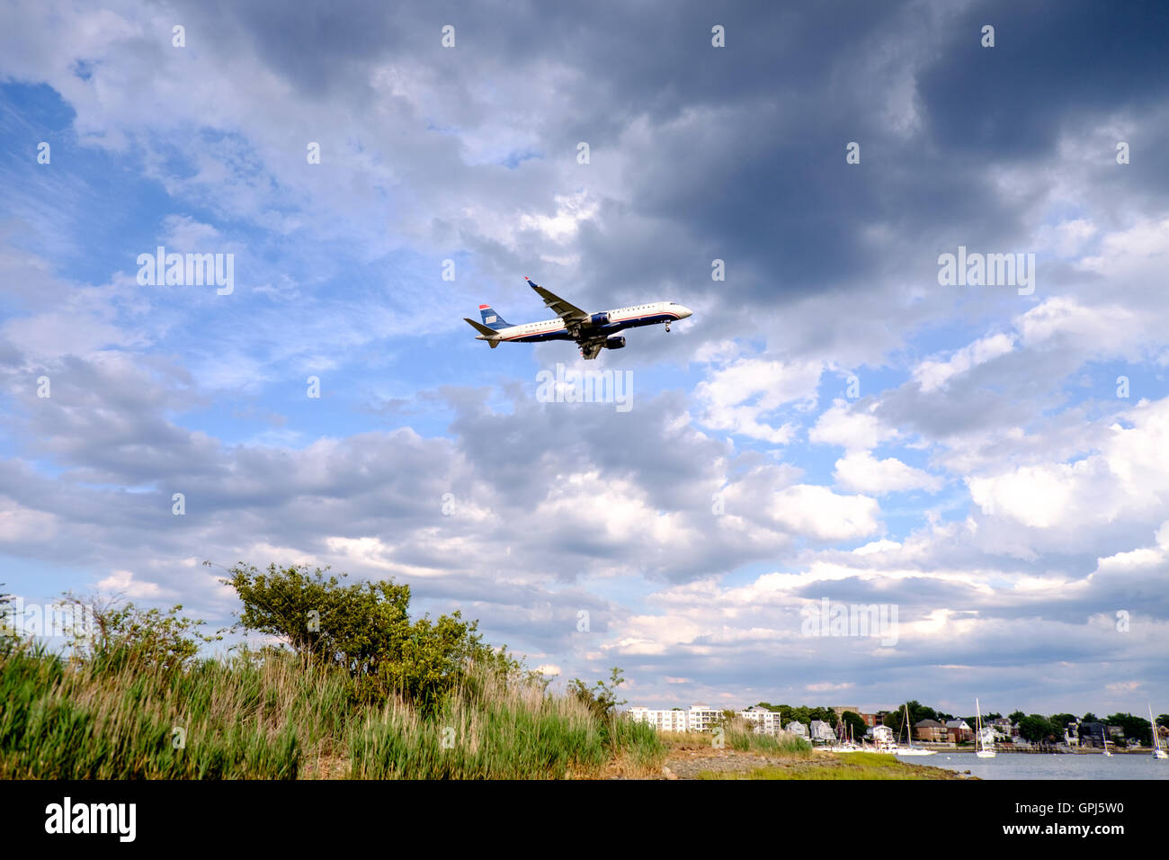 US Airways Jet fliegen über Orient Heights und über den Boden an der Boston Logan International Airport, USA Stockfoto