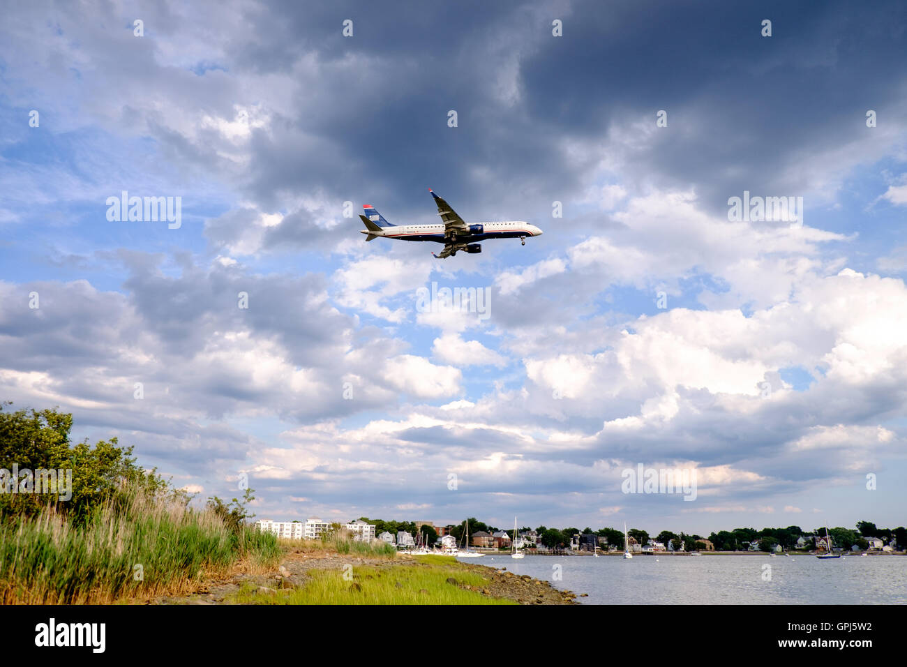 US Airways Jet fliegen über Orient Heights und über den Boden an der Boston Logan International Airport, USA Stockfoto