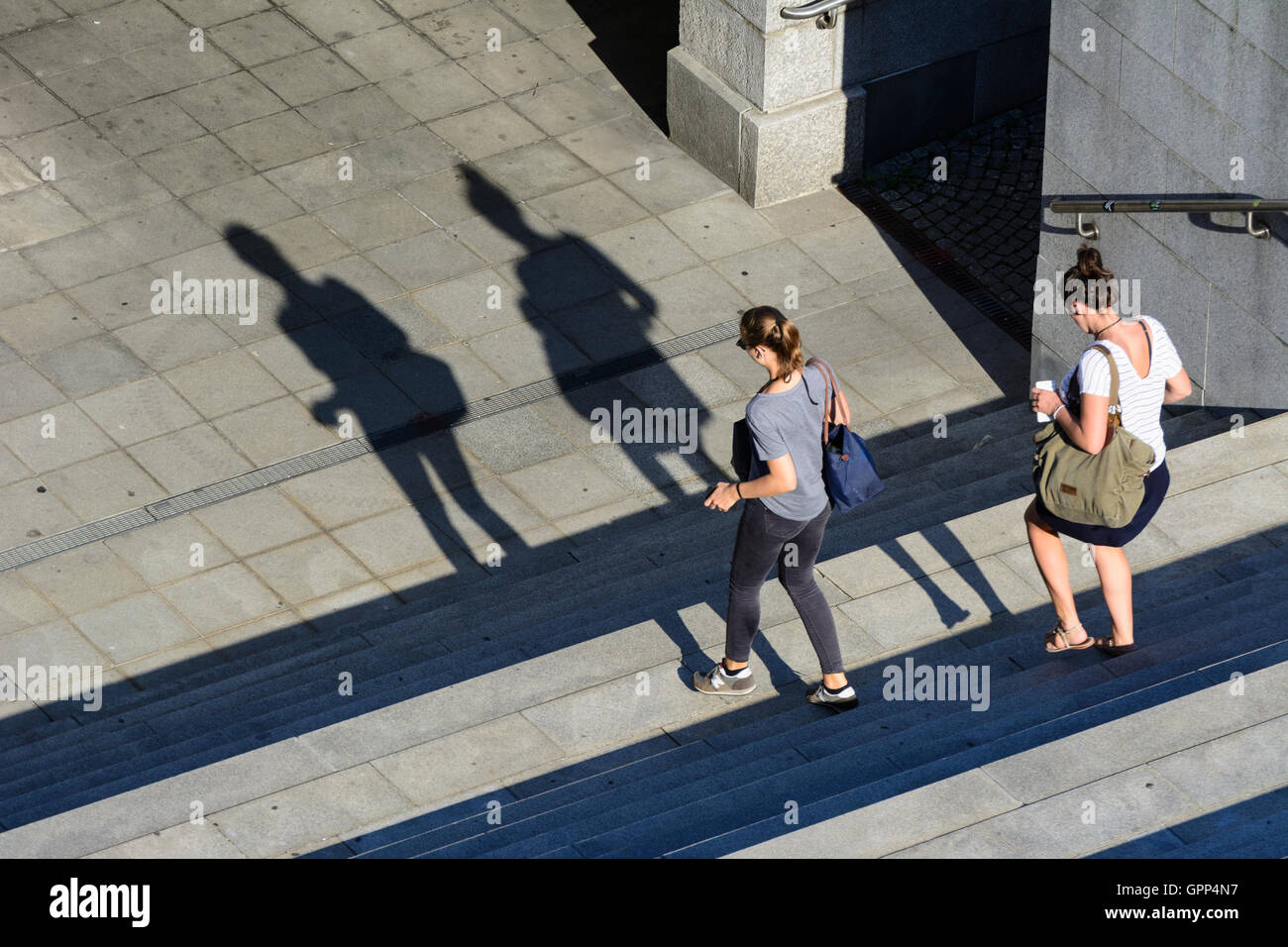 2 Frauen laufen auf Schritte, lange Schatten in Linz, Oberösterreich, Oberösterreich, Österreich Stockfoto
