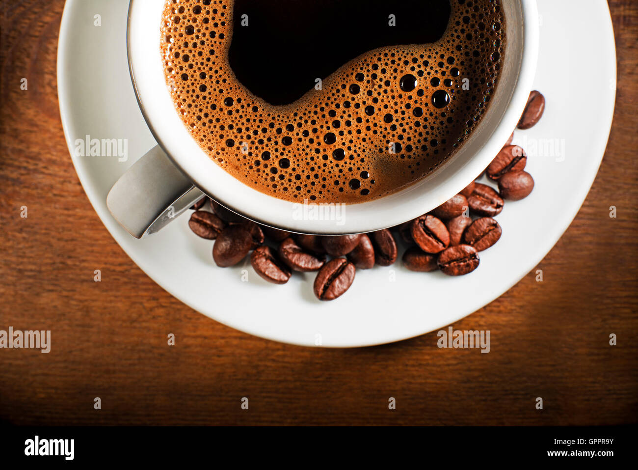 Tasse Kaffee und Bohnen auf einem hölzernen Hintergrund. Stockfoto