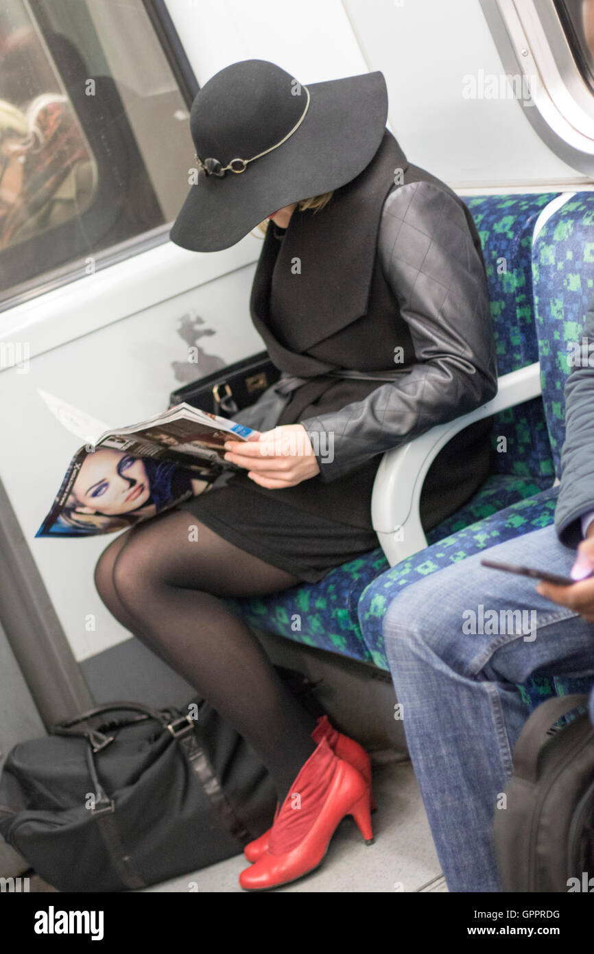 Frau liest am Rohr u großen Hut Stockfoto