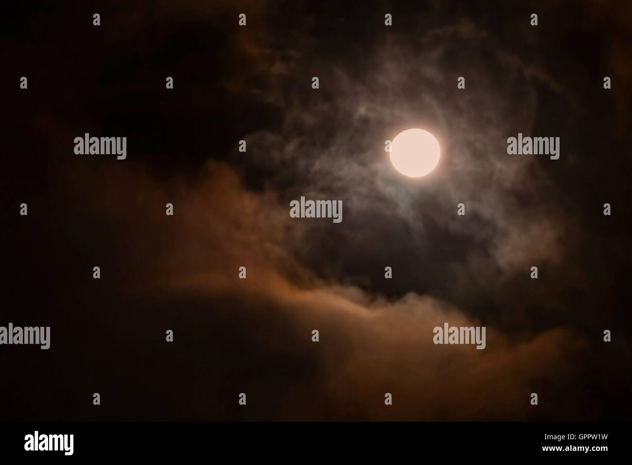 Vollmond über dunklen schwarzen Himmel mit flauschigen Wolken in der Nacht Stockfoto