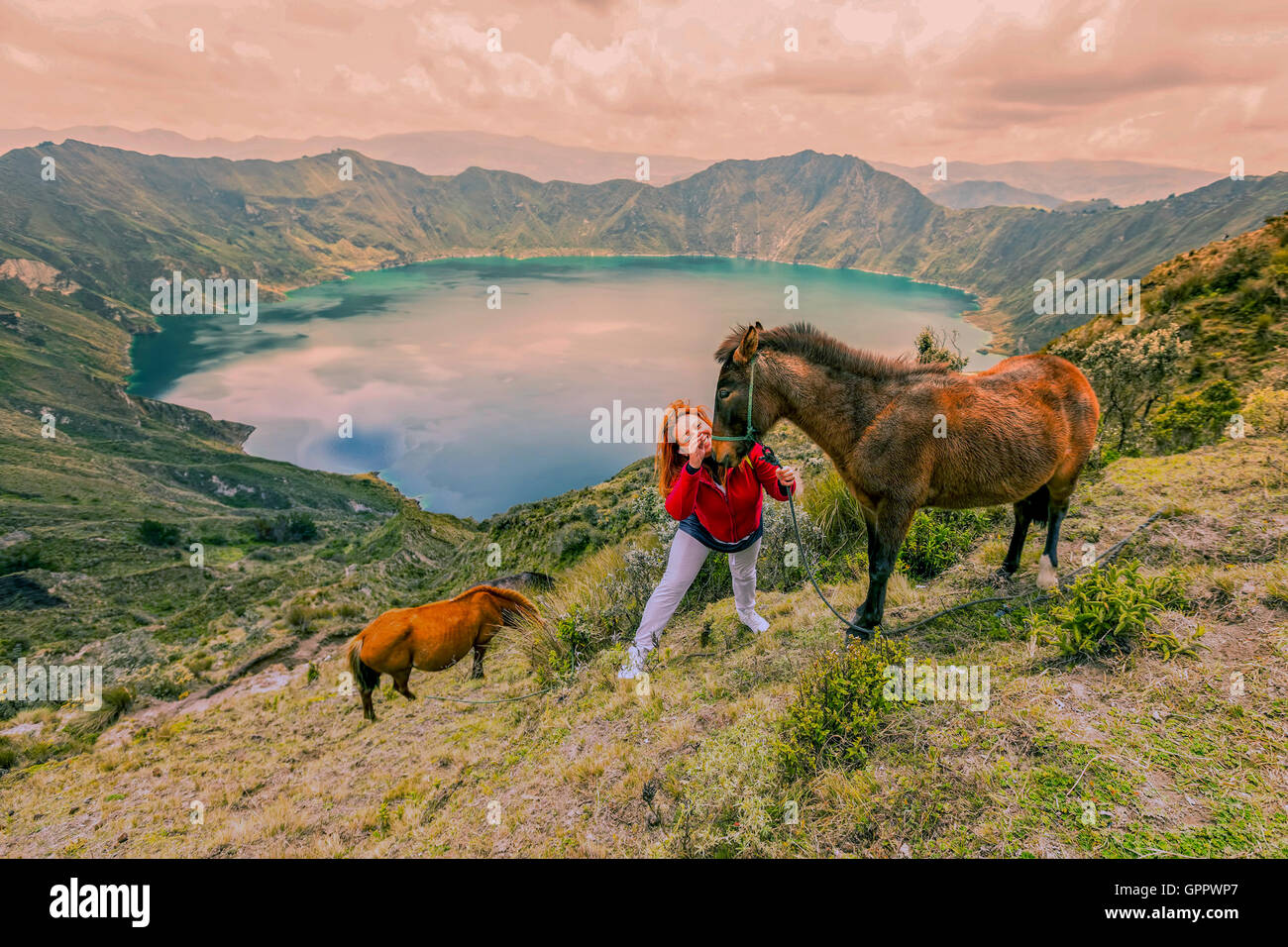 Junge Frau Wandern mit zwei Pferden am Rande des Berges, Quilotoa See im Hintergrund, Ecuador, Südamerika Stockfoto