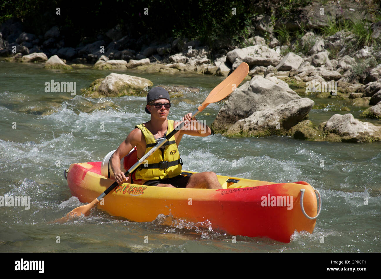 Tourismus, Tourist, Wassersport. Ein junger Mann Kanu die felsigen schnellen fließenden turbulenten Gewässern des Flusses Drôme. In der Nähe von Saillans, La Drôme, Frankreich. Stockfoto