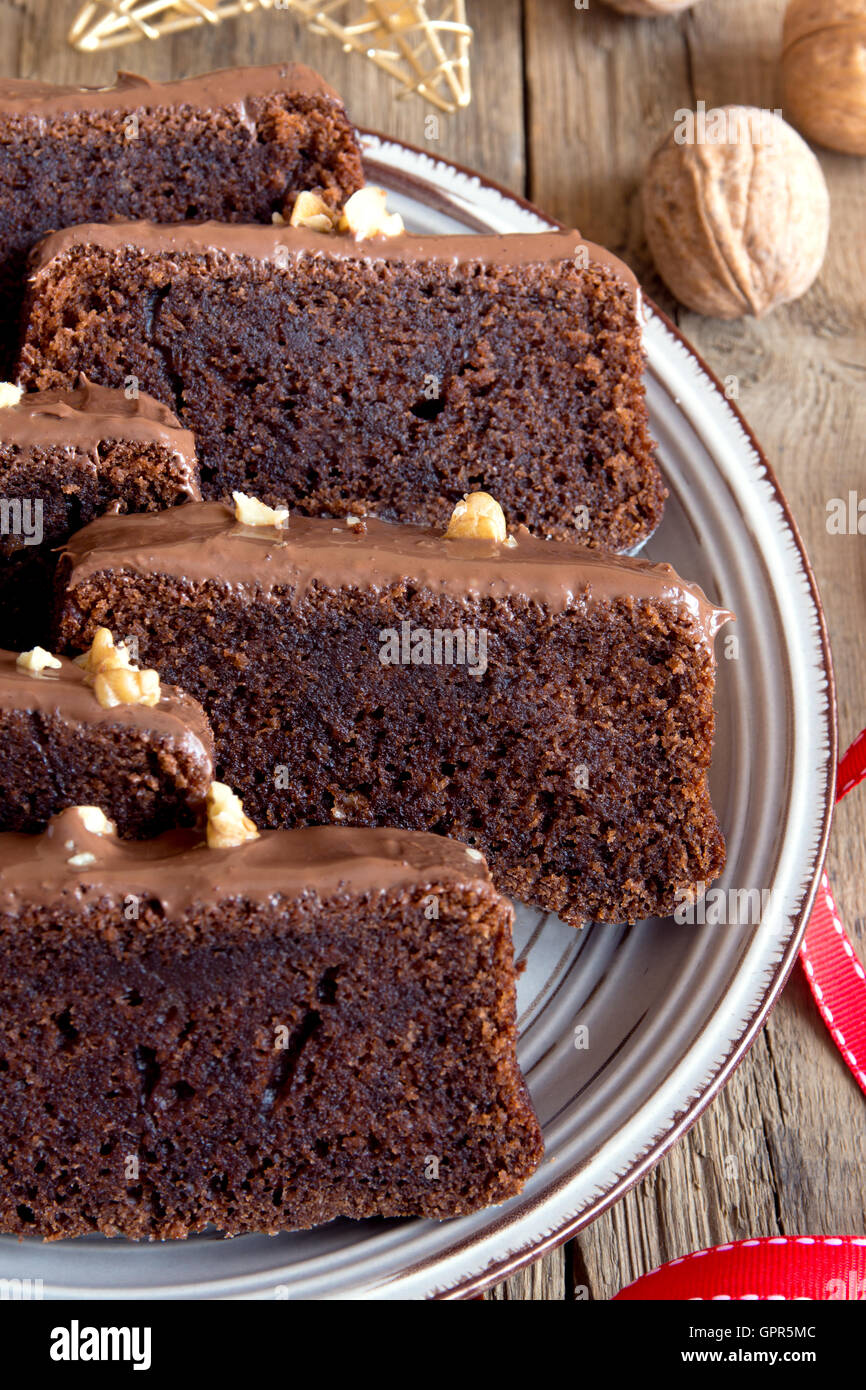 In Scheiben geschnittene Schokoladenkuchen mit Nüssen und Gewürzen zu Weihnachten über rustikale Holz Hintergrund Stockfoto
