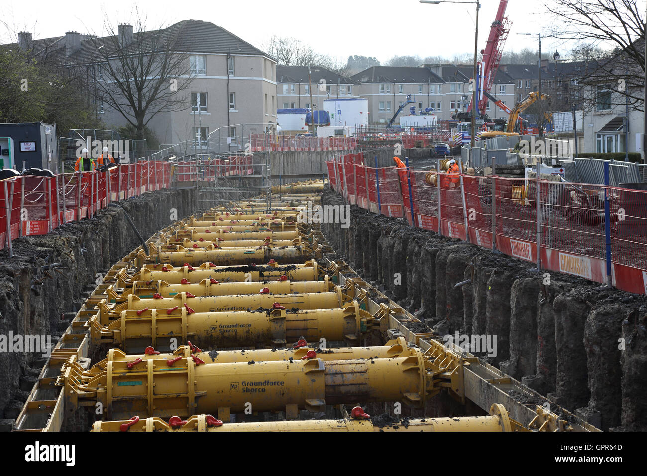 Die Baugrube für neue, große Durchmesser Kanalisation durch Schild Halle Bezirk von Glasgow. Zeigt Traggerüst und die umliegenden Häuser. Stockfoto