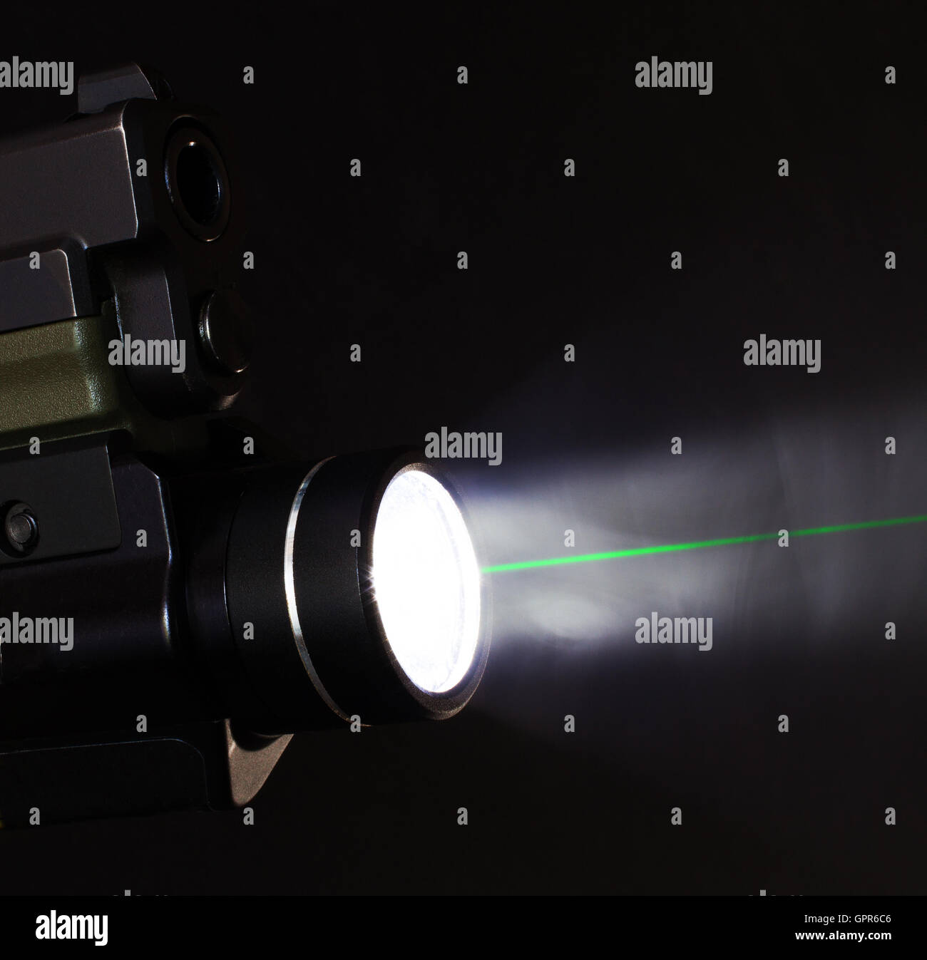 Grüner Laser und Taschenlampe, die auf eine Pistole Stockfoto