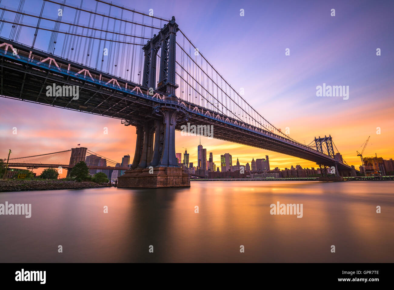 New York City an der Manhattan Bridge über den East River während des Sonnenuntergangs. Stockfoto
