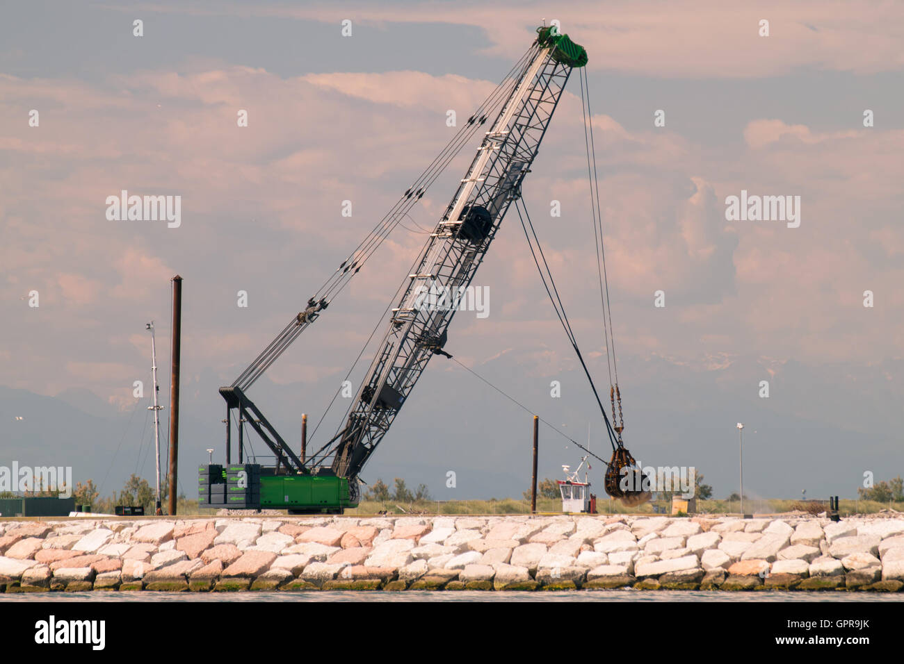 Schnappen Sie sich Kran in Aktion, einen Deich zu bauen. Stockfoto