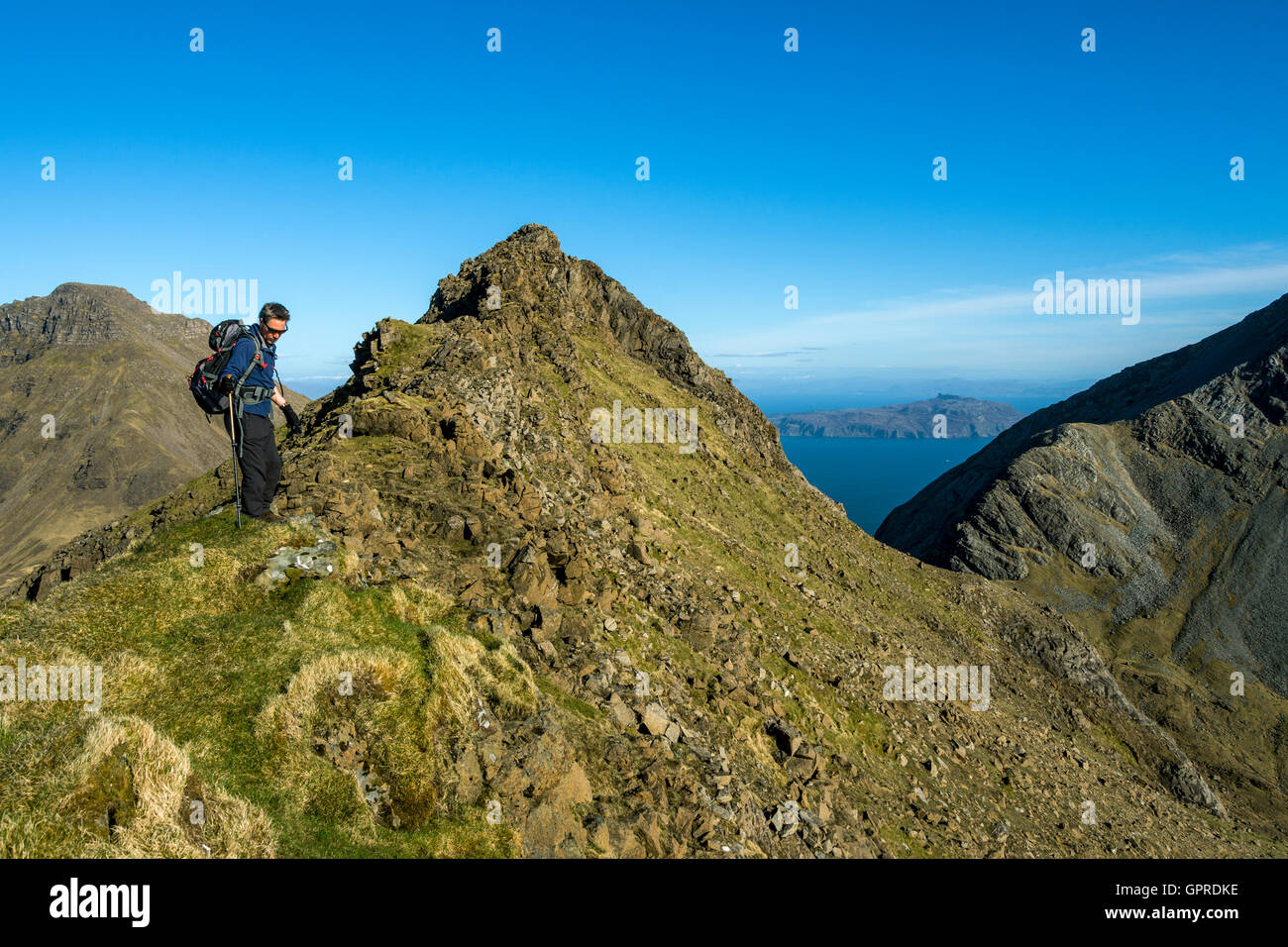 Walker am Gipfel Grat des Trollabhal in Rum Cuillin Hills, Isle of Rum, Schottland, Großbritannien.  Askival auf der linken Seite. Stockfoto