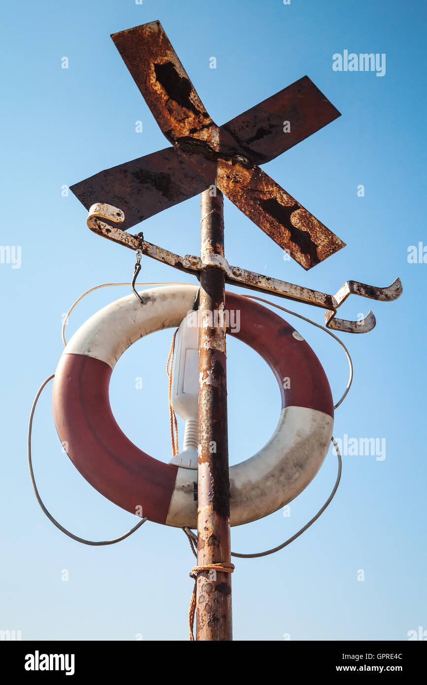 Alte rostige Kreuz geformten Navigation Schild mit Rettungsring Stockfoto