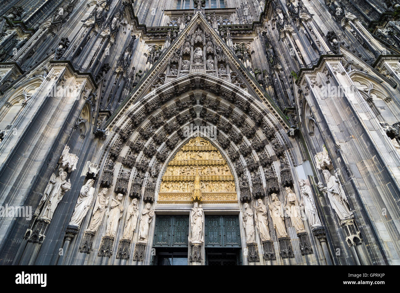 Eingang zum Kölner Dom. Figuren von Heiligen an der Fassade. Stockfoto